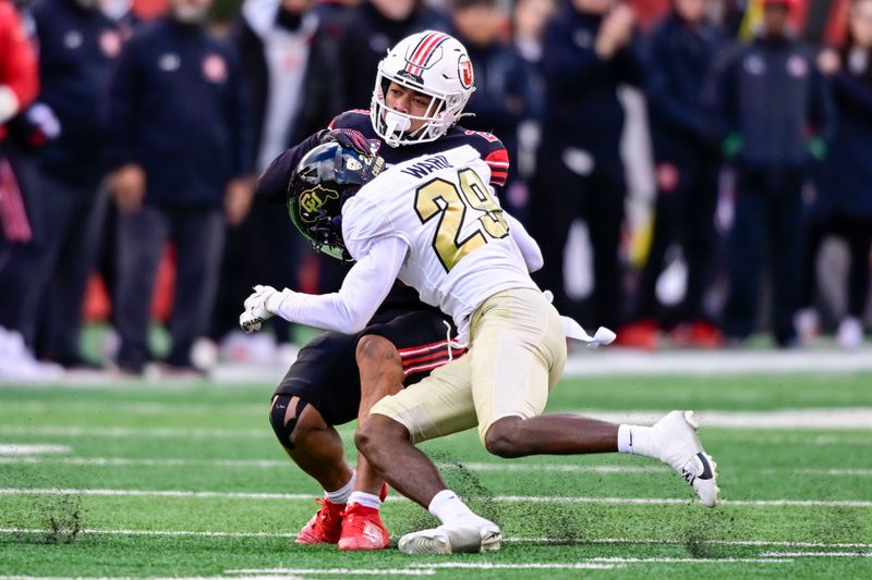 Nov 25, 2023; Salt Lake City, Utah, USA; Utah Utes safety Sione Vaki (28) is tackled by Colorado Buffaloes safety Rodrick Ward (29) at Rice-Eccles Stadium. Mandatory Credit: Christopher Creveling-USA TODAY Sports