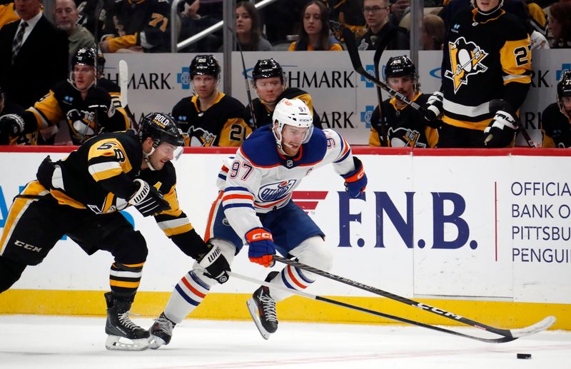 Mar 10, 2024; Pittsburgh, Pennsylvania, USA;  Edmonton Oilers center Connor McDavid (97) chases the puck ahaed of Pittsburgh Penguins defenseman Kris Letang (58) during the second period at PPG Paints Arena. The Oilers won 4-0. Mandatory Credit: Charles LeClaire-USA TODAY Sports