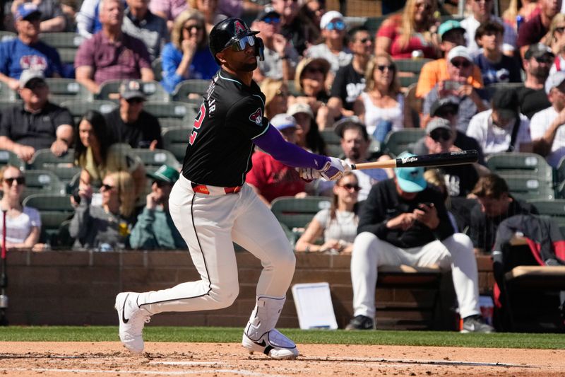 Mar 8, 2024; Salt River Pima-Maricopa, Arizona, USA; Arizona Diamondbacks left fielder Lourdes Gurriel Jr. (12) hits against the Chicago Cubs in the third inning at Salt River Fields at Talking Stick. Mandatory Credit: Rick Scuteri-USA TODAY Sports