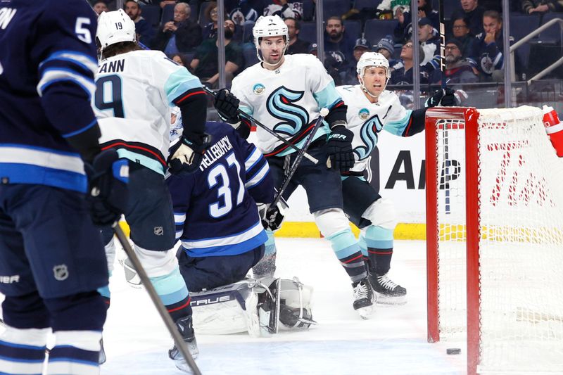 Mar 5, 2024; Winnipeg, Manitoba, CAN; Seattle Kraken defenseman Justin Schultz (4) scores on Winnipeg Jets goaltender Connor Hellebuyck (37) in the first period at Canada Life Centre. Mandatory Credit: James Carey Lauder-USA TODAY Sports