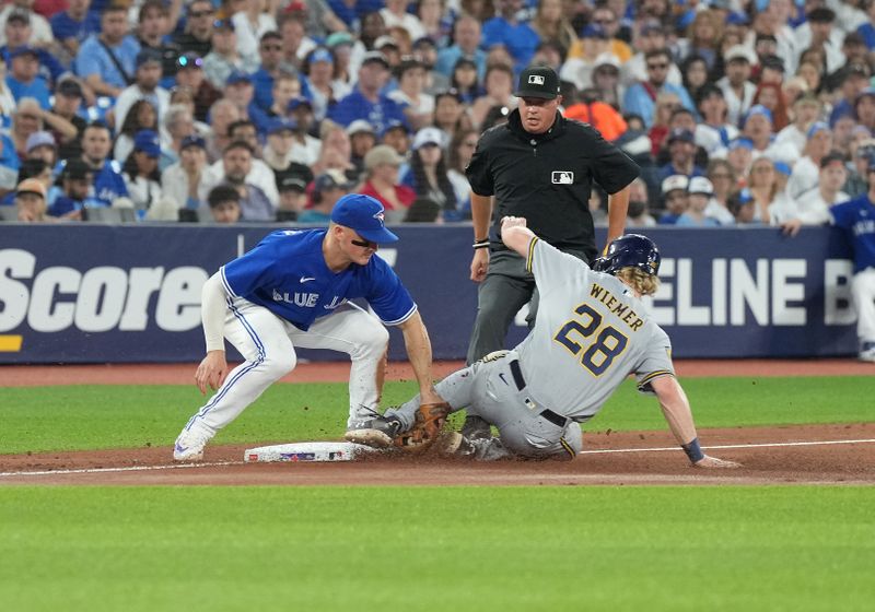 May 31, 2023; Toronto, Ontario, CAN; Milwaukee Brewers center fielder Joey Wiemer (28) slides into third base safe ahead of the tag from Toronto Blue Jays third baseman Matt Chapman (26) during the seventh inning inning at Rogers Centre. Mandatory Credit: Nick Turchiaro-USA TODAY Sports