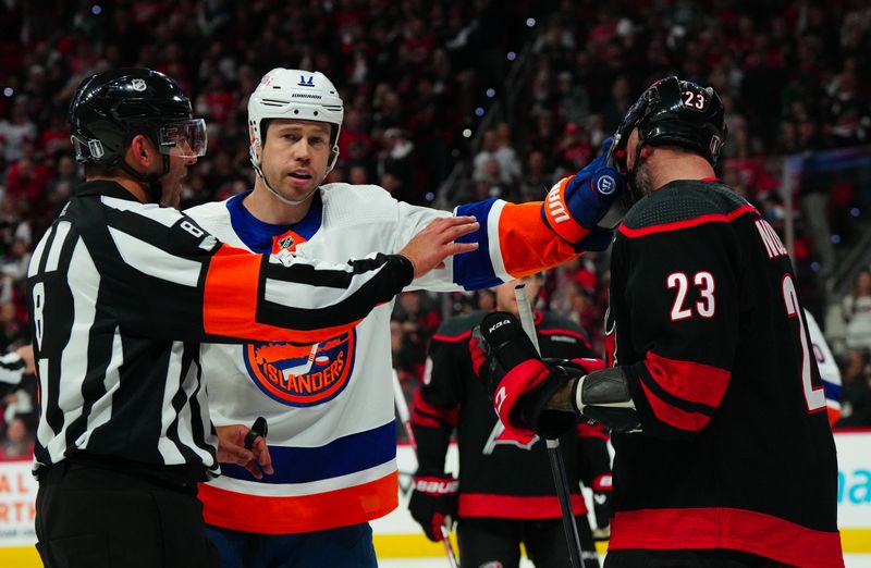 Apr 22, 2024; Raleigh, North Carolina, USA; New York Islanders left wing Matt Martin (17) grabs hold of Carolina Hurricanes right wing Stefan Noesen (23) face shield during the third period in game two of the first round of the 2024 Stanley Cup Playoffs at PNC Arena. Mandatory Credit: James Guillory-USA TODAY Sports