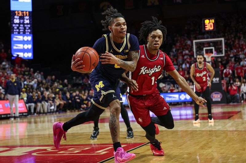 Feb 29, 2024; Piscataway, New Jersey, USA; Michigan Wolverines guard Dug McDaniel (0) rebounds against Rutgers Scarlet Knights guard Jamichael Davis (1) during the second half at Jersey Mike's Arena. Mandatory Credit: Vincent Carchietta-USA TODAY Sports