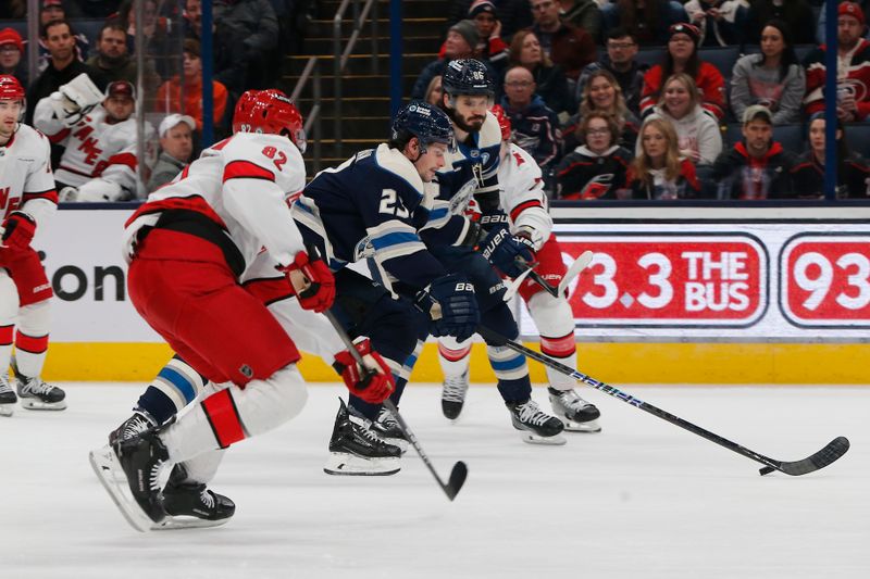 Dec 31, 2024; Columbus, Ohio, USA; Columbus Blue Jackets center Sean Monahan (23) controls the puck as Carolina Hurricanes center Jesperi Kotkaniemi (82) defends during the first period at Nationwide Arena. Mandatory Credit: Russell LaBounty-Imagn Images