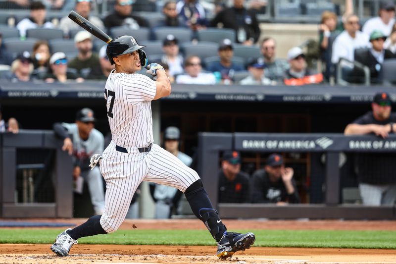 May 4, 2024; Bronx, New York, USA;  New York Yankees designated hitter Giancarlo Stanton (27) hits an RBI single in the first inning against the Detroit Tigers at Yankee Stadium. Mandatory Credit: Wendell Cruz-USA TODAY Sports