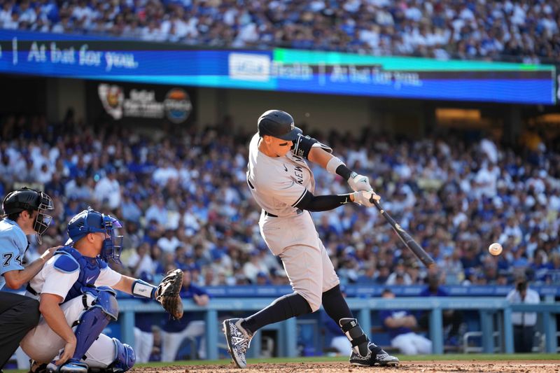 Jun 3, 2023; Los Angeles, California, USA; New York Yankees right fielder Aaron Judge (99) follows through on a home run in the sixth inning as Los Angeles Dodgers catcher Will Smith (16) and home plate umpire John Tumpane (74) watch at Dodger Stadium. Mandatory Credit: Kirby Lee-USA TODAY Sports