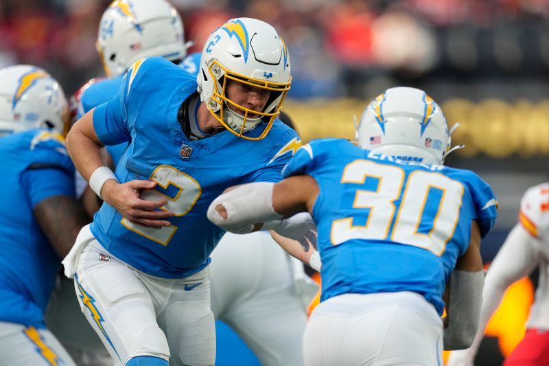 Los Angeles Chargers quarterback Easton Stick (2) hands off to running back Austin Ekeler (30) during an NFL football game against the Kansas City Chiefs Monday, Jan. 8, 2024, in Inglewood, Calif. (AP Photo/Ashley Landis)