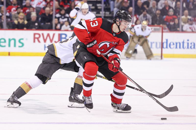 Jan 22, 2024; Newark, New Jersey, USA; New Jersey Devils defenseman Luke Hughes (43) plays the puck as Vegas Golden Knights right wing Jonas Rondbjerg (46) defends during the second period at Prudential Center. Mandatory Credit: Vincent Carchietta-USA TODAY Sports