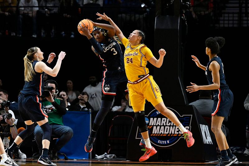 Apr 1, 2024; Portland, OR, USA; UConn Huskies forward Aaliyah Edwards (3) pulls down a rebound during the first half against USC Trojans forward Kaitlyn Davis (24) in the finals of the Portland Regional of the NCAA Tournament at the Moda Center. Mandatory Credit: Troy Wayrynen-USA TODAY Sports