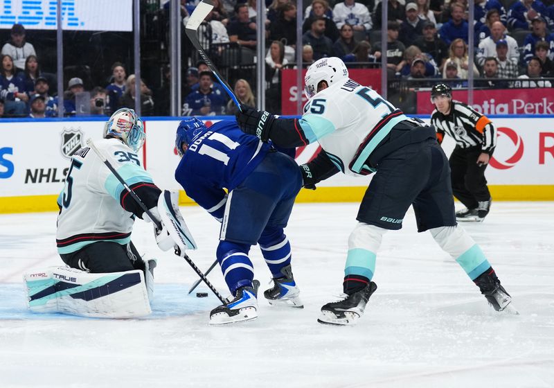 Oct 18, 2025; Toronto, Ontario, CAN; Toronto Maple Leafs center Max Domi (11) controls the puck defended by Seattle Kraken defenseman Ryan Lindgren (55) during the third period at Scotiabank Arena. Mandatory Credit: Nick Turchiaro-Imagn Images
