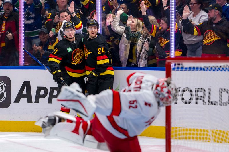 Oct 28, 2024; Vancouver, British Columbia, CAN; Vancouver Canucks forward Nils Hoglander (21) and  forward Pius Suter (24) celebrate Suter’s goal against the Carolina Hurricanes during the third period at Rogers Arena. Mandatory Credit: Bob Frid-Imagn Images