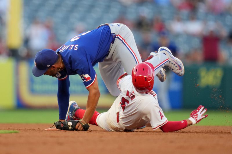 Jul 10, 2024; Anaheim, California, USA; Los Angeles Angels shortstop Zach Neto (9) is tagged out by Texas Rangers second baseman Marcus Semien (2) in the third inning  at Angel Stadium. Mandatory Credit: Kirby Lee-USA TODAY Sports