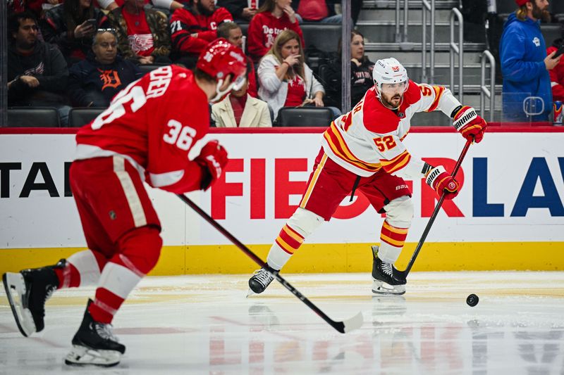 Nov 27, 2024; Detroit, Michigan, USA; Calgary Flames defenseman MacKenzie Weegar (52) clears the puck as Detroit Red Wings right wing Christian Fischer (36) pursues during the second period at Little Caesars Arena. Mandatory Credit: Tim Fuller-Imagn Images