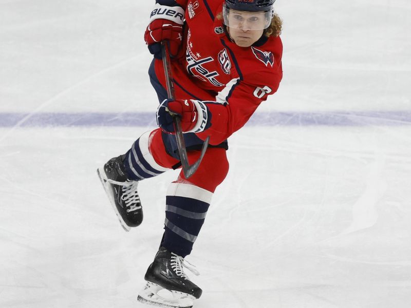 Dec 3, 2024; Washington, District of Columbia, USA; Washington Capitals defenseman Jakob Chychrun (6) shoots the puck as San Jose Sharks left wing William Eklund (72) defends in the first period at Capital One Arena. Mandatory Credit: Geoff Burke-Imagn Images