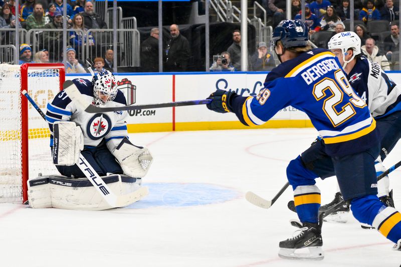 Dec 17, 2025; St. Louis, Missouri, USA; Winnipeg Jets goaltender Connor Hellebuyck (37) defends the net against St. Louis Blues right wing Jonatan Berggren (29) during the second period at Enterprise Center. Mandatory Credit: Jeff Curry-Imagn Images