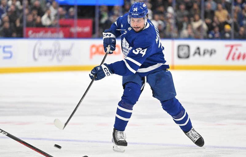 Dec 30, 2023; Toronto, Ontario, CAN; Toronto Maple Leafs forward Auston Matthews (34) shoots the puck against the Carolina Hurricanes in the first period at Scotiabank Arena. Mandatory Credit: Dan Hamilton-USA TODAY Sports