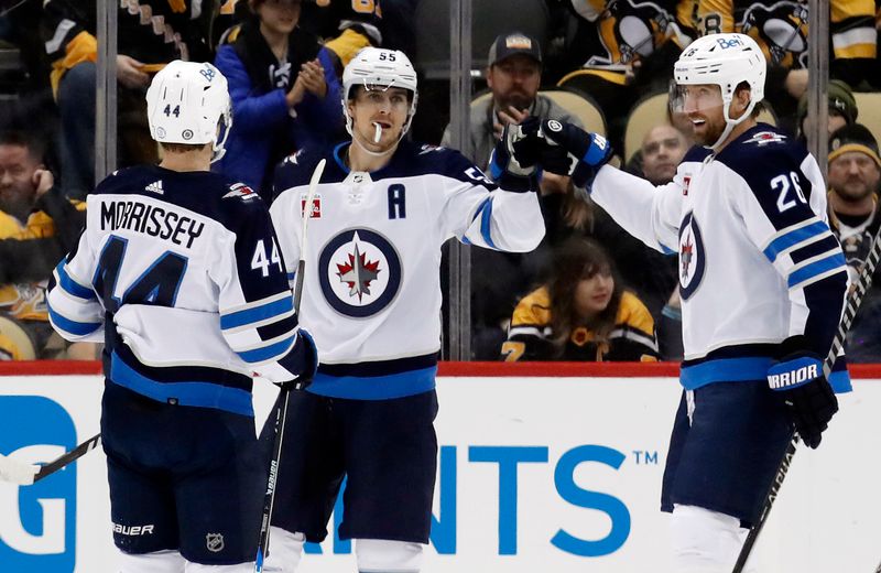 Jan 13, 2023; Pittsburgh, Pennsylvania, USA;  Winnipeg Jets center Mark Scheifele (55) celebrates his goal with defenseman Josh Morrissey (44) and right wing Blake Wheeler (26) against the Pittsburgh Penguins during the third period at PPG Paints Arena. The Jets won 4-1. Mandatory Credit: Charles LeClaire-USA TODAY Sports