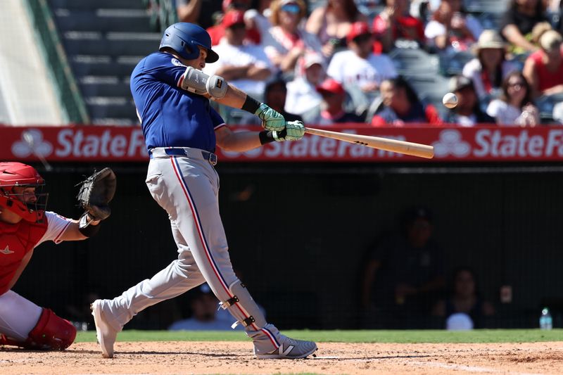 Sep 29, 2024; Anaheim, California, USA;  Texas Rangers first baseman Nathaniel Lowe (30) hits a home run during the eighth inning against the Los Angeles Angels at Angel Stadium. Mandatory Credit: Kiyoshi Mio-Imagn Images