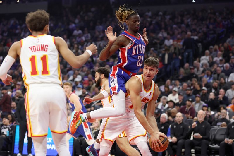 SACRAMENTO, CALIFORNIA - NOVEMBER 18: Keon Ellis #23 of the Sacramento Kings goes for a rebound against Bogdan Bogdanovic #13 of the Atlanta Hawks in the first half at Golden 1 Center on November 18, 2024 in Sacramento, California. NOTE TO USER: User expressly acknowledges and agrees that, by downloading and/or using this photograph, user is consenting to the terms and conditions of the Getty Images License Agreement.   (Photo by Ezra Shaw/Getty Images)