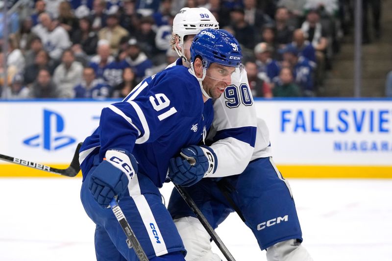 Oct 21, 2024; Toronto, Ontario, CAN; Tampa Bay Lightning defenseman Janis Moser (90) and Toronto Maple Leafs forward John Tavares (91) battle for position during the first period at Scotiabank Arena. Mandatory Credit: John E. Sokolowski-Imagn Images