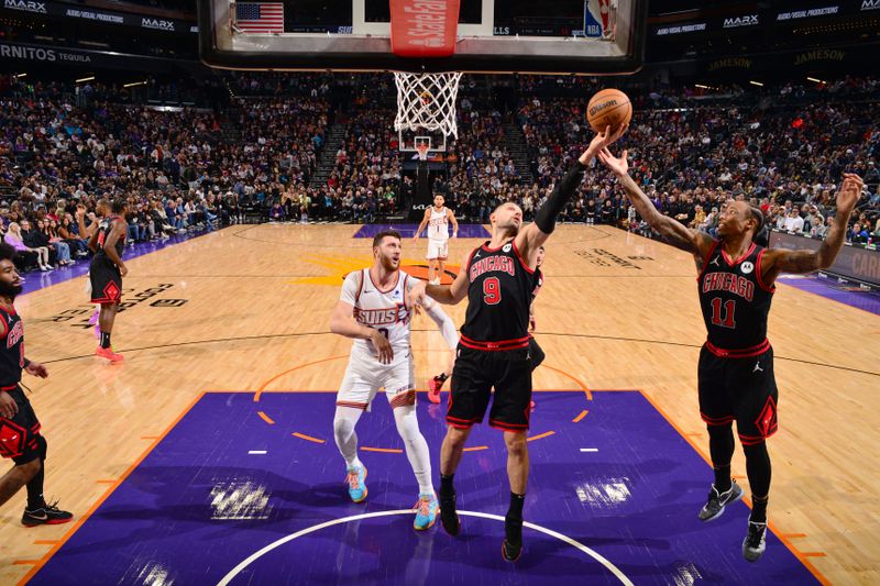 PHOENIX, AZ - JANUARY 22:  Nikola Vucevic #9 and DeMar DeRozan #11 of the Chicago Bulls rebounds the ball during the game against the Phoenix Suns on January 22, 2024 at Footprint Center in Phoenix, Arizona. NOTE TO USER: User expressly acknowledges and agrees that, by downloading and or using this photograph, user is consenting to the terms and conditions of the Getty Images License Agreement. Mandatory Copyright Notice: Copyright 2024 NBAE (Photo by Barry Gossage/NBAE via Getty Images)