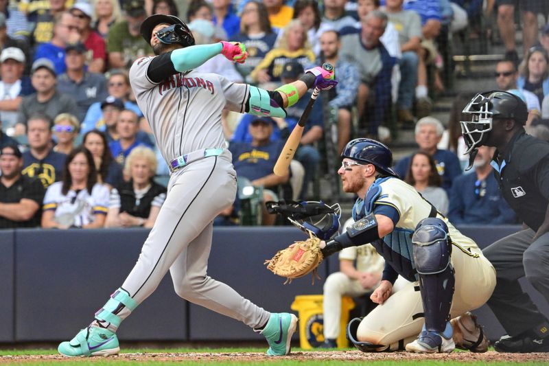 Aug 28, 2025; Milwaukee, Wisconsin, USA; Arizona Diamondbacks left fielder Lourdes Gurriel (12) knocks the face mask off Milwaukee Brewers catcher Danny Jansen (33) while hitting a single in the fourth inning at American Family Field. Mandatory Credit: Benny Sieu-Imagn Images