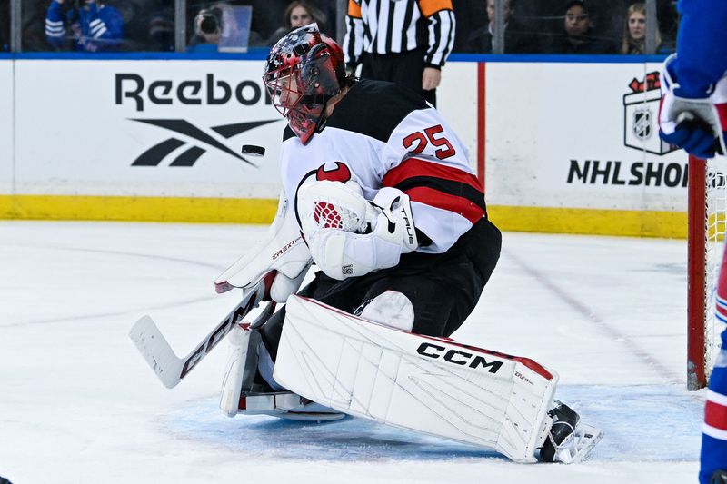 Dec 2, 2024; New York, New York, USA;  New Jersey Devils goaltender Jacob Markstrom (25) makes a save against the New York Rangers during the second period at Madison Square Garden. Mandatory Credit: Dennis Schneidler-Imagn Images