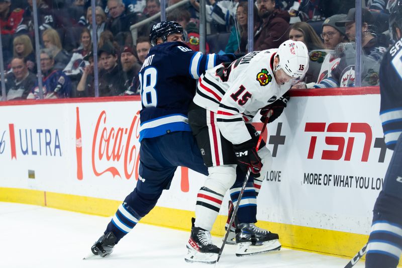 Jan 11, 2024; Winnipeg, Manitoba, CAN; Winnipeg Jets defenseman Nate Schmidt (88) boards Chicago Blackhawks forward Joey Anderson (15) during the first period at Canada Life Centre. Mandatory Credit: Terrence Lee-USA TODAY Sports