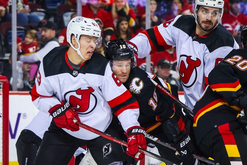 Dec 9, 2023; Calgary, Alberta, CAN; Calgary Flames center Jonathan Huberdeau (10) and New Jersey Devils left wing Jesper Bratt (63) fight for position during the second period at Scotiabank Saddledome. Mandatory Credit: Sergei Belski-USA TODAY Sports