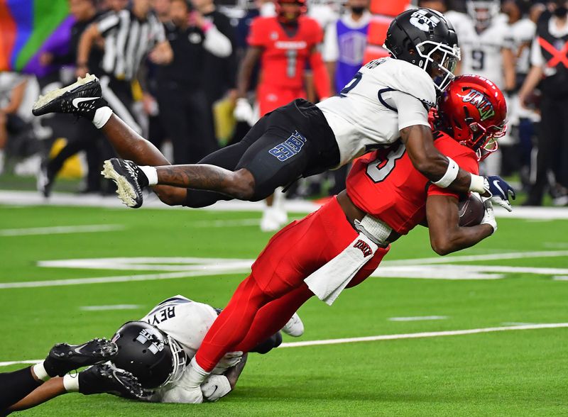 Oct 16, 2021; Paradise, Nevada, USA;  Utah State Aggies safety Ajani Carter (12) tackles UNLV Rebels running back Charles Williams (8) during the first half at Allegiant Stadium. Mandatory Credit: Stephen R. Sylvanie-USA TODAY Sports