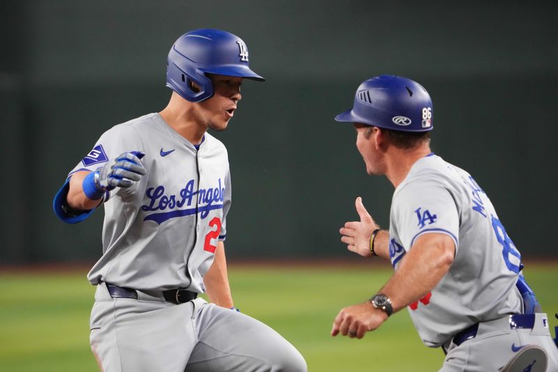 Aug 31, 2024; Phoenix, Arizona, USA; Los Angeles Dodgers shortstop Tommy Edman (25) slaps hands with Los Angeles Dodgers first base coach Clayton McCullough (86) after hitting a two RBI single against the Arizona Diamondbacks during the ninth inning at Chase Field. Mandatory Credit: Joe Camporeale-USA TODAY Sports