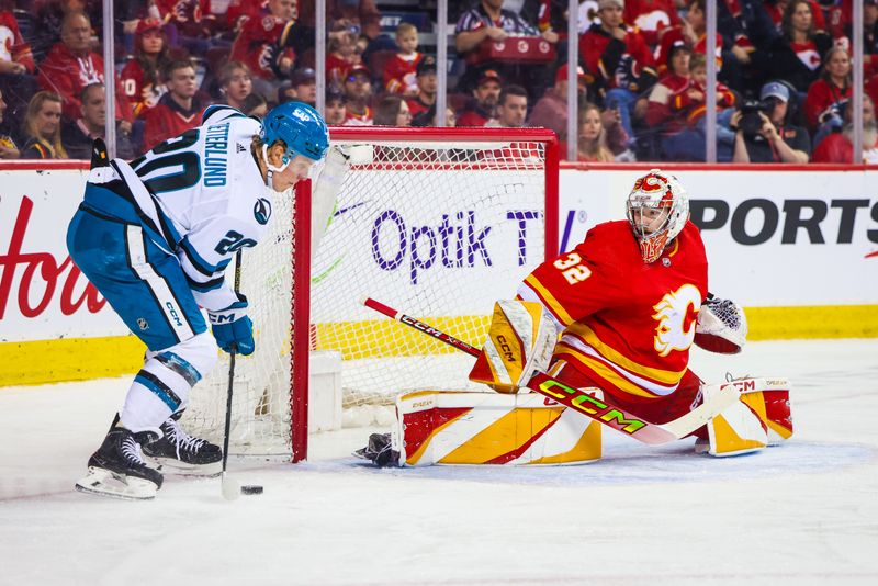 Apr 18, 2024; Calgary, Alberta, CAN; Calgary Flames goaltender Dustin Wolf (32) guards his net against San Jose Sharks left wing Fabian Zetterlund (20) during the first period at Scotiabank Saddledome. Mandatory Credit: Sergei Belski-USA TODAY Sports