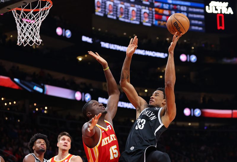 ATLANTA, GEORGIA - DECEMBER 06:  Nic Claxton #33 of the Brooklyn Nets drives against Clint Capela #15 of the Atlanta Hawks during the fourth quarter at State Farm Arena on December 06, 2023 in Atlanta, Georgia.  NOTE TO USER: User expressly acknowledges and agrees that, by downloading and/or using this photograph, user is consenting to the terms and conditions of the Getty Images License Agreement.  (Photo by Kevin C. Cox/Getty Images)