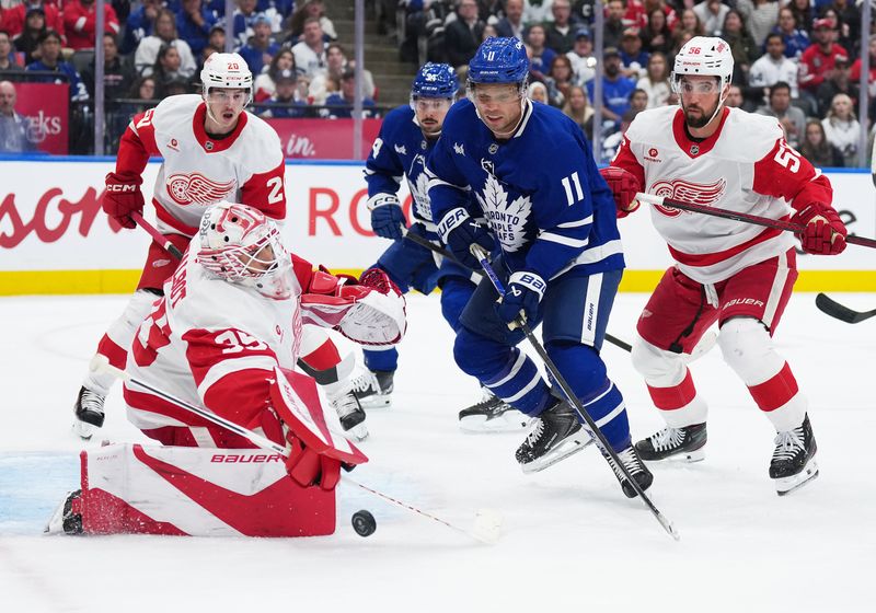 Oct 2, 2025; Toronto, Ontario, CAN; Toronto Maple Leafs center Max Domi (11) battles for the puck in front of Detroit Red Wings goaltender Cam Talbot (39) during the first period at Scotiabank Arena. Mandatory Credit: Nick Turchiaro-Imagn Images