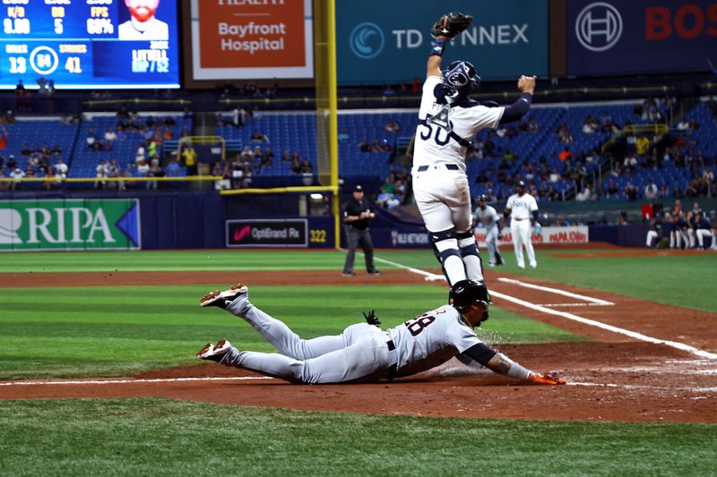 Apr 22, 2024; St. Petersburg, Florida, USA; Detroit Tigers shortstop Javier Baez (28) slides safe into home plate as Tampa Bay Rays catcher Rene Pinto (50) attempts to catch the ball during the fifth inning at Tropicana Field. Mandatory Credit: Kim Klement Neitzel-USA TODAY Sports