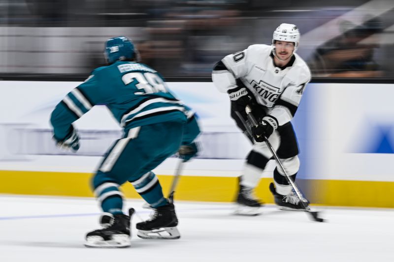 Oct 29, 2024; San Jose, California, USA; Los Angeles Kings left wing Tanner Jeannot (10) brings the puck up the ice against San Jose Sharks defenseman Mario Ferraro (38) in the first period at SAP Center at San Jose. Mandatory Credit: Eakin Howard-Imagn Images