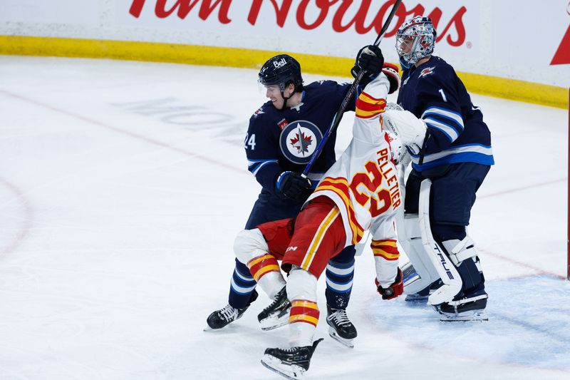 Jan 26, 2025; Winnipeg, Manitoba, CAN;  Winnipeg Jets defenseman Hayden Fleury (24) jostles for position with Calgary Flames forward Jacob Pelletier (22) during the third period at Canada Life Centre. Mandatory Credit: Terrence Lee-Imagn Images