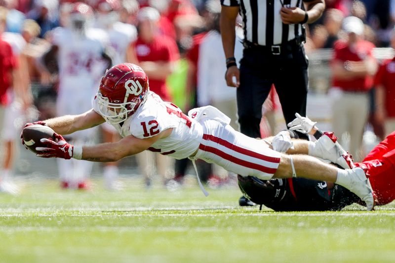 Sep 23, 2023; Cincinnati, Ohio, USA; Oklahoma Sooners wide receiver Drake Stoops (12) advances the ball against Cincinnati Bearcats defensive back Taj Ward (15) in the second half at Nippert Stadium. Mandatory Credit: Katie Stratman-USA TODAY Sports