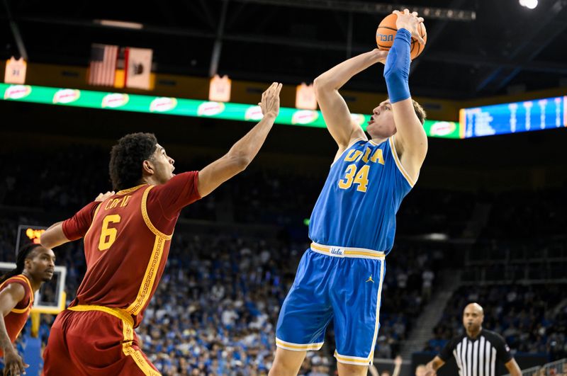 Feb 24, 2026; Los Angeles, California, USA; UCLA Bruins forward Tyler Bilodeau (34) shoots over Southern California Trojans forward Jacob Cofie (6) during the second half at Pauley Pavilion presented by Wescom Financial. Mandatory Credit: Robert Hanashiro-Imagn Images