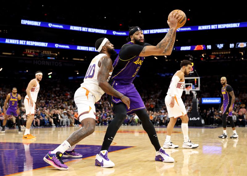 PHOENIX, ARIZONA - OCTOBER 28: Anthony Davis #3 of the Los Angeles Lakers makes a move on Royce O'Neale #00 of the Phoenix Suns during the second half at Footprint Center on October 28, 2024 in Phoenix, Arizona. NOTE TO USER: User expressly acknowledges and agrees that, by downloading and or using this photograph, User is consenting to the terms and conditions of the Getty Images License Agreement. (Photo by Christian Petersen/Getty Images)