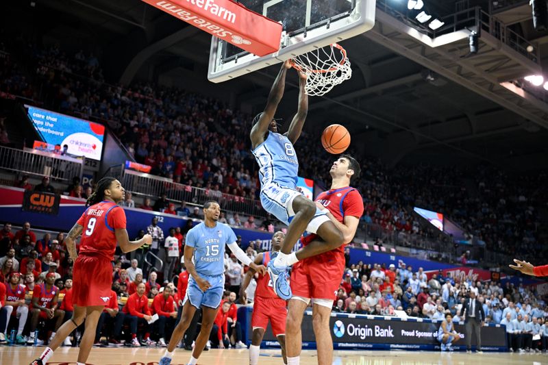 Jan 3, 2026; Dallas, Texas, USA; North Carolina Tar Heels forward Caleb Wilson (8) dunks the ball over SMU Mustangs center Samet Yigitoglu (24) during the first half at Moody Coliseum. Mandatory Credit: Jerome Miron-Imagn Images