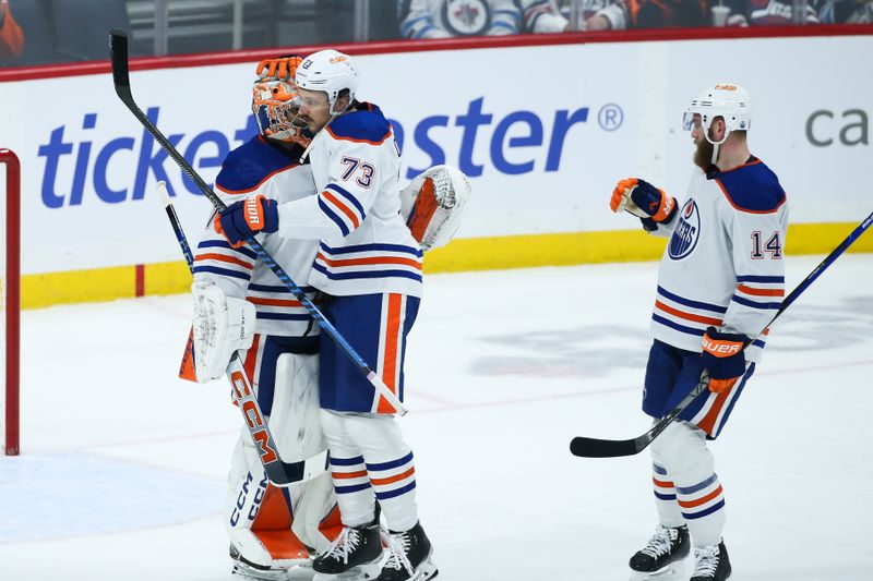 Nov 30, 2023; Winnipeg, Manitoba, CAN; Edmonton Oilers goalie Stuart Skinner (74) is congratulated by Edmonton Oilers defenseman Vincent Desharnais (73) on his win against the Winnipeg Jets at the end of the third period at Canada Life Centre. Mandatory Credit: Terrence Lee-USA TODAY Sports