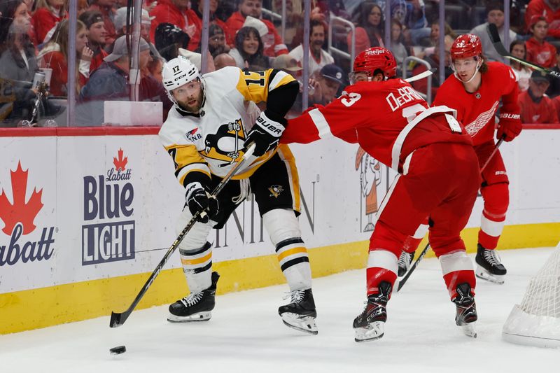 Oct 18, 2023; Detroit, Michigan, USA; Pittsburgh Penguins right wing Bryan Rust (17) skates with the puck defended by Detroit Red Wings right wing Alex DeBrincat (93) in the third period at Little Caesars Arena. Mandatory Credit: Rick Osentoski-USA TODAY Sports