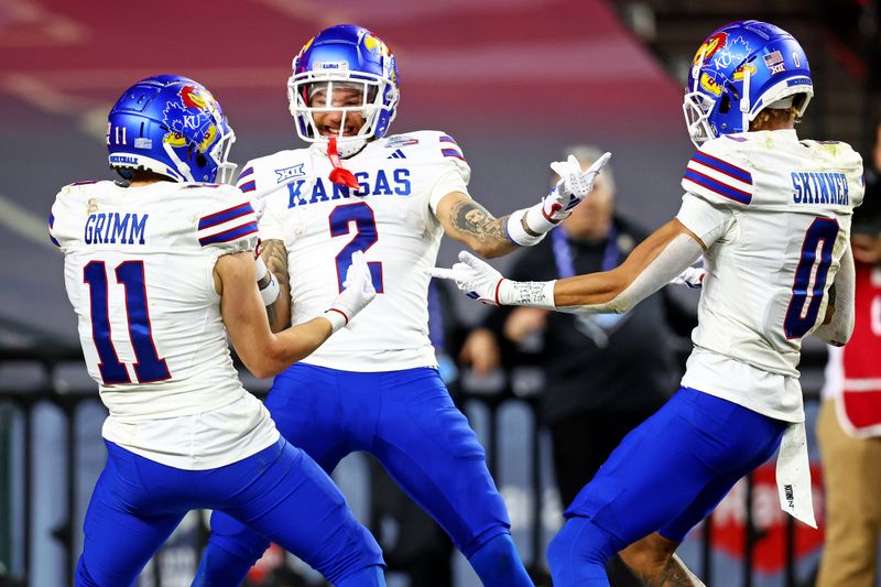 Dec 26, 2023; Phoenix, AZ, USA; Kansas Jayhawks wide receiver Lawrence Arnold (2) celebrates with wide receiver Luke Grimm (11) and wide receiver Quentin Skinner (0) during the second half against the UNLV Rebels in the Guaranteed Rate Bowl at Chase Field. Mandatory Credit: Mark J. Rebilas-USA TODAY Sports