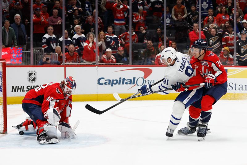 Nov 13, 2024; Washington, District of Columbia, USA; Toronto Maple Leafs center John Tavares (91) scores the game winning overtime goal on Washington Capitals goaltender Logan Thompson (48) as Capitals defenseman John Carlson (74) defends at Capital One Arena. Mandatory Credit: Geoff Burke-Imagn Images