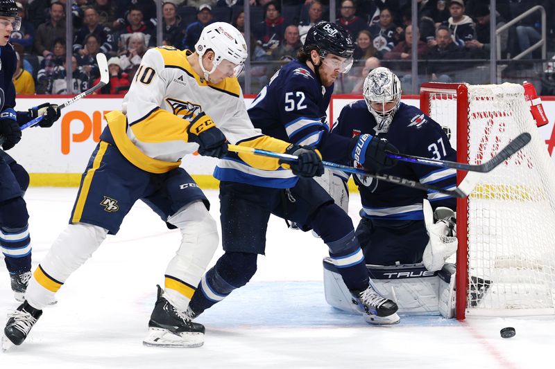 Jan 7, 2025; Winnipeg, Manitoba, CAN; Nashville Predators center Colton Sissons (10) and Winnipeg Jets defenseman Dylan Coghlan (52) go after a rebound after a save byWinnipeg Jets goaltender Connor Hellebuyck (37) in the first period at Canada Life Centre. Mandatory Credit: James Carey Lauder-Imagn Images