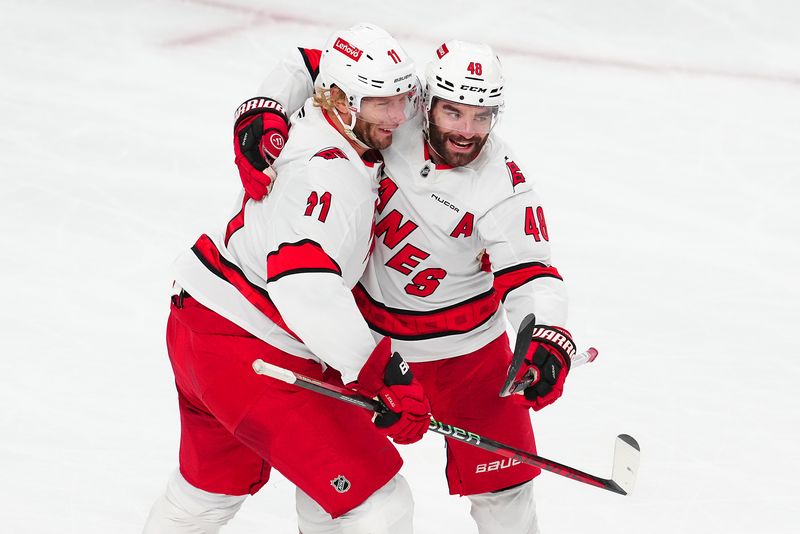 Nov 11, 2024; Las Vegas, Nevada, USA; Carolina Hurricanes left wing Jordan Martinook (48) celebrates with Carolina Hurricanes center Jordan Staal (11) after scoring an empty net goal against the Vegas Golden Knights during the third period at T-Mobile Arena. Mandatory Credit: Stephen R. Sylvanie-Imagn Images