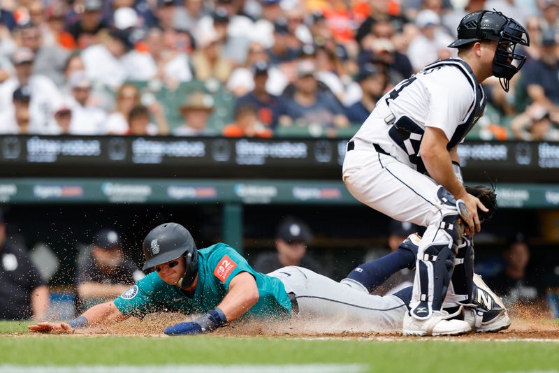 Jul 12, 2025; Detroit, Michigan, USA; Seattle Mariners third baseman Ben Williamson (9) dives in safe at home ahead of the throw to Detroit Tigers catcher Jake Rogers (34) in the fourth inning at Comerica Park. Mandatory Credit: Rick Osentoski-Imagn Images