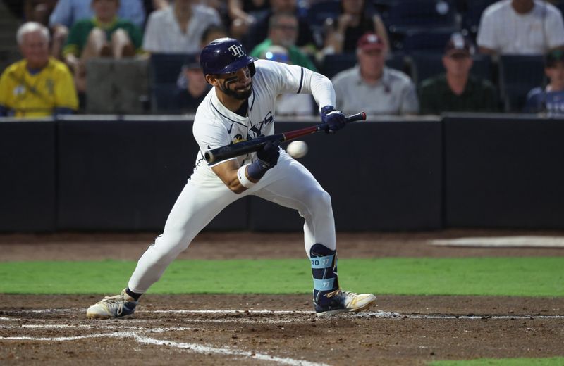 Jun 30, 2025; Tampa, Florida, USA;  Tampa Bay Rays outfielder Jose Caballero (77) hits a bunt RBI single against the Athletics during the fourth inning at George M. Steinbrenner Field. Mandatory Credit: Kim Klement Neitzel-Imagn Images