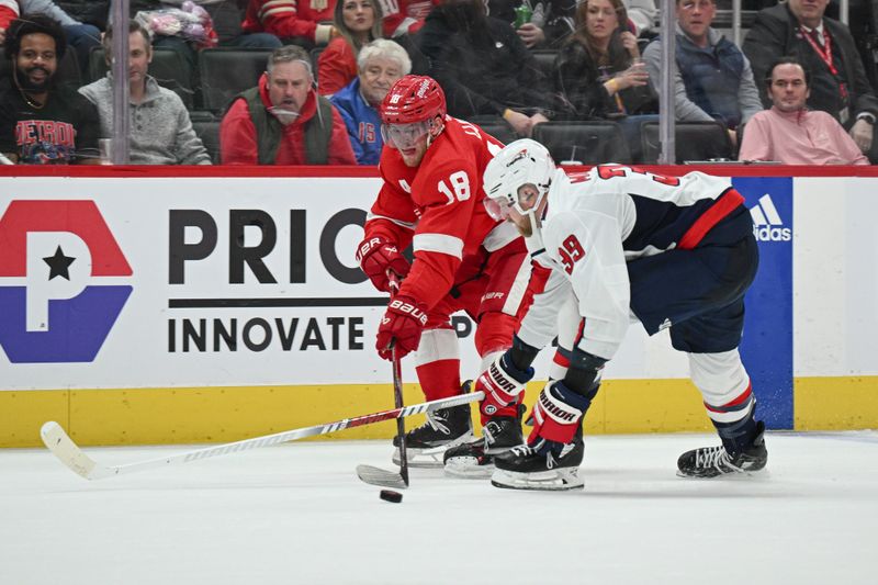 Feb 27, 2024; Detroit, Michigan, USA; Detroit Red Wings center Andrew Copp (18) makes a pass for an assist as Washington Capitals right wing Anthony Mantha (39) defends during the second period at Little Caesars Arena. Mandatory Credit: Tim Fuller-USA TODAY Sports